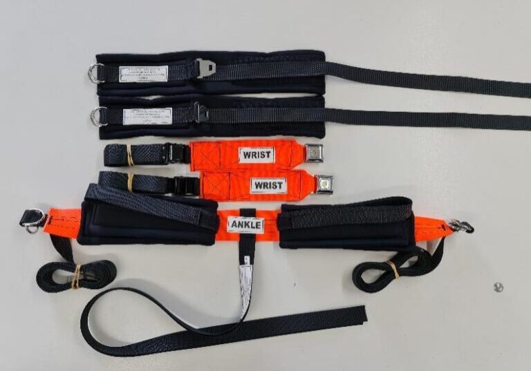 A flurescent orang and black restraint set attached to a hospital bed.